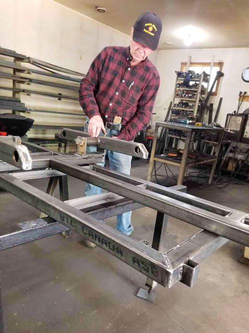 >Allan in his workshop creating a walking beam for his ATV trailers. Photo: Marilyn Collie